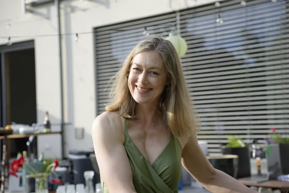 A woman smiling at an outdoor summer gathering